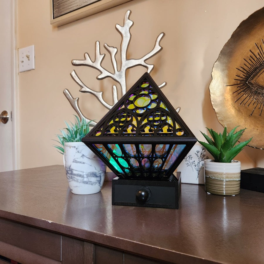 The Cathedral switched off on a desk in daylight, next to a white coral sculpture and a small plant