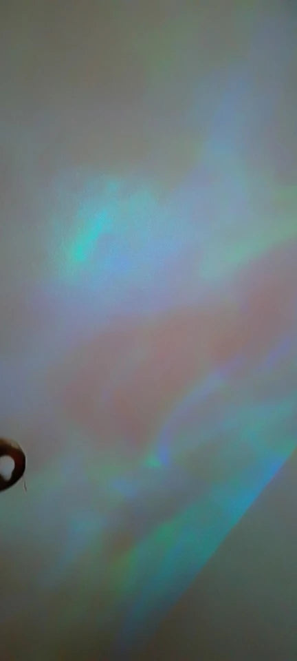 Water-ripple light in blue and green moving across a wall