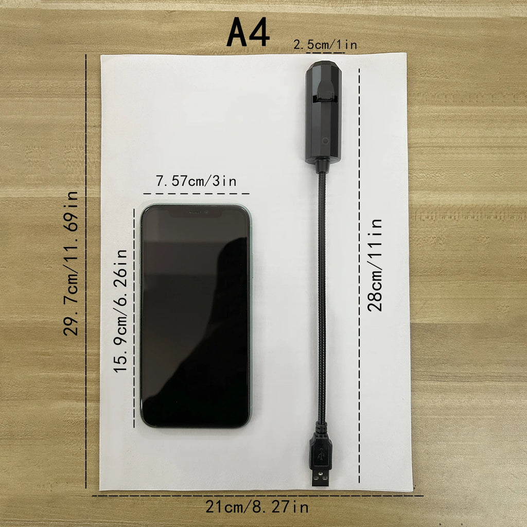 The projector on a sheet of A4 paper for scale, 28 cm long with a 2.5 cm head