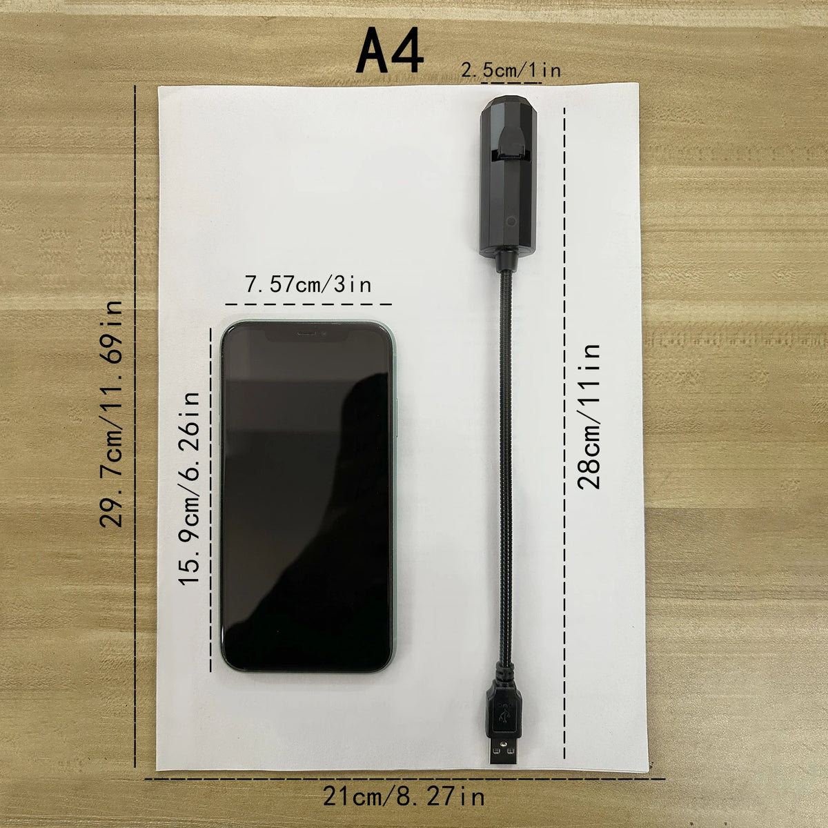 The projector on a sheet of A4 paper for scale, 28 cm long with a 2.5 cm head