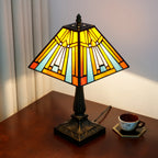 Lit pyramid lamp from the side, showing the square shade and the bronze-look base